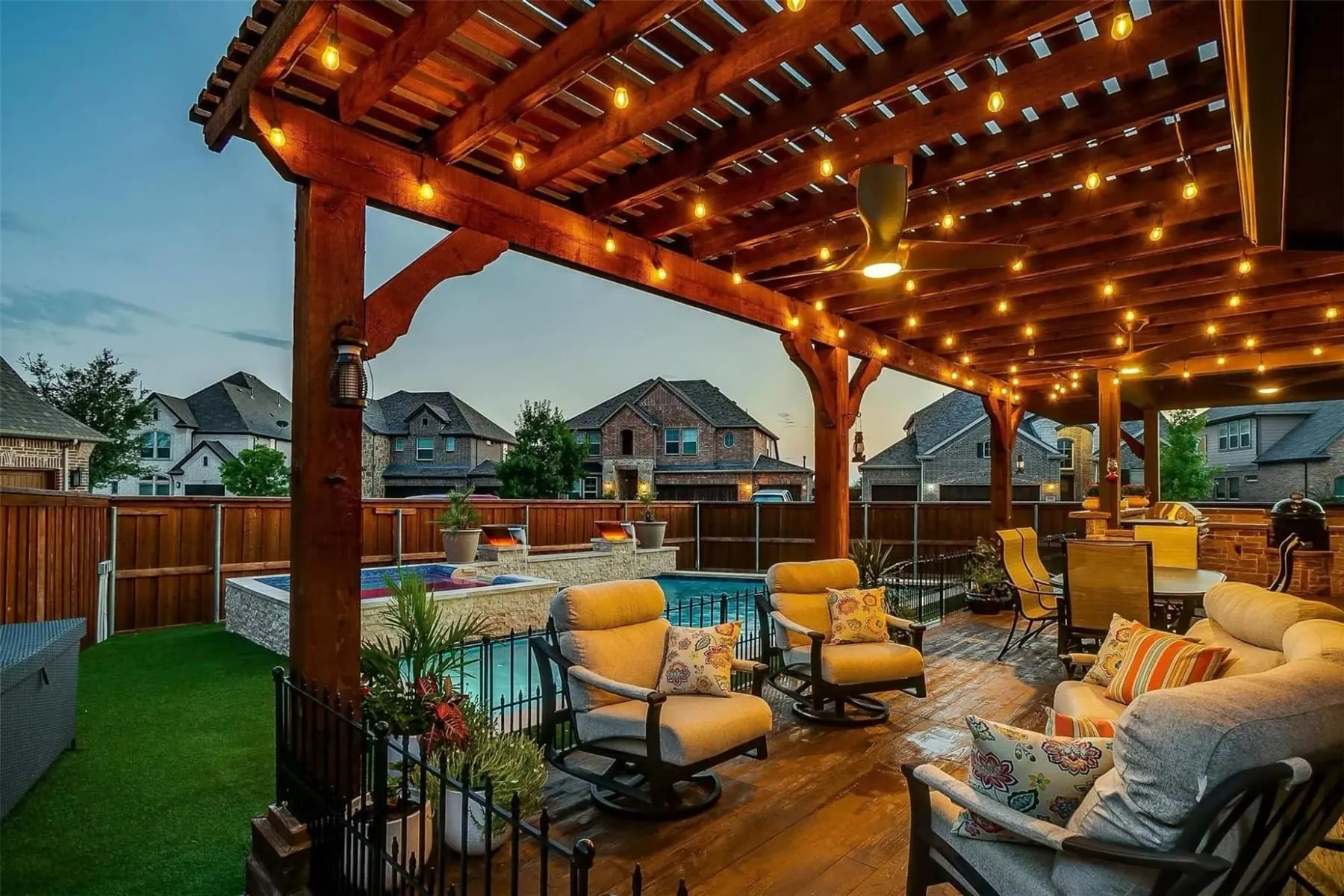 Cedar pergola with string lights beside a custom pool
